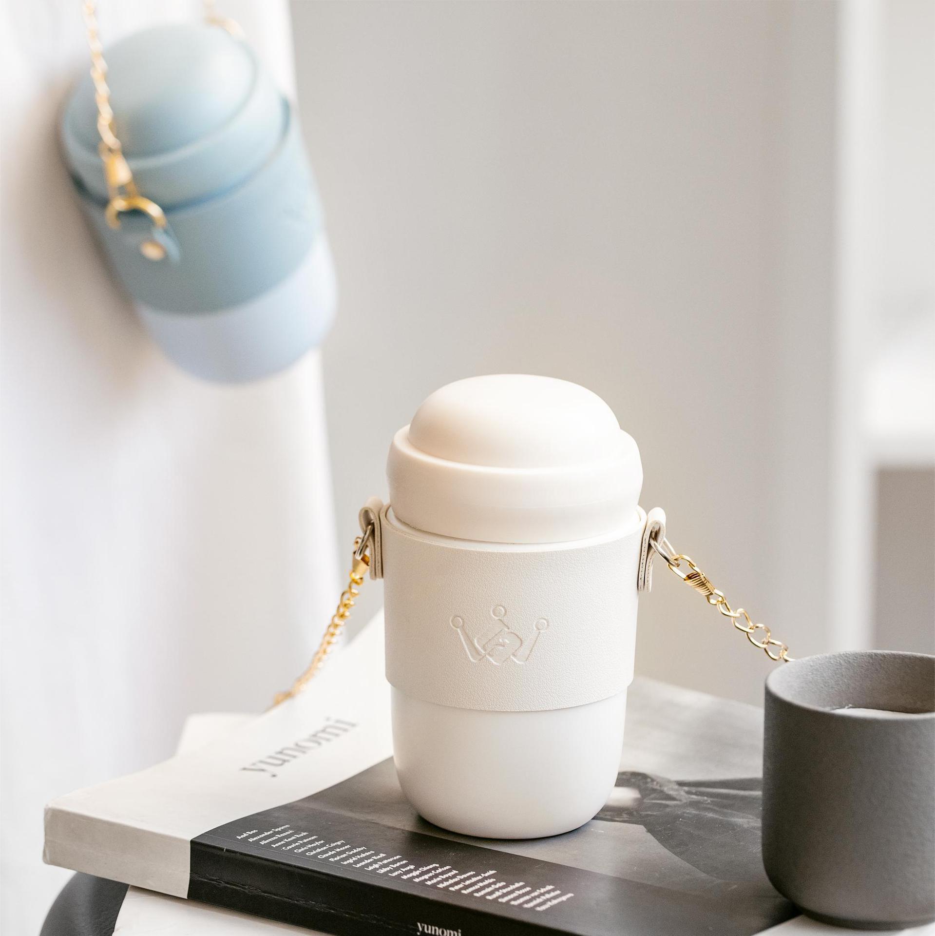 White ceramic water bottle with gold chain strap and minimalist design