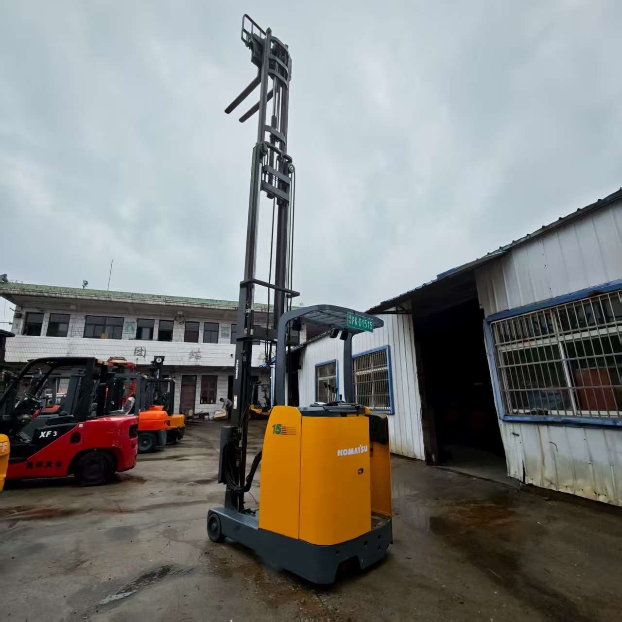 Front view of used Komatsu electric reach stacker showing controls and mast